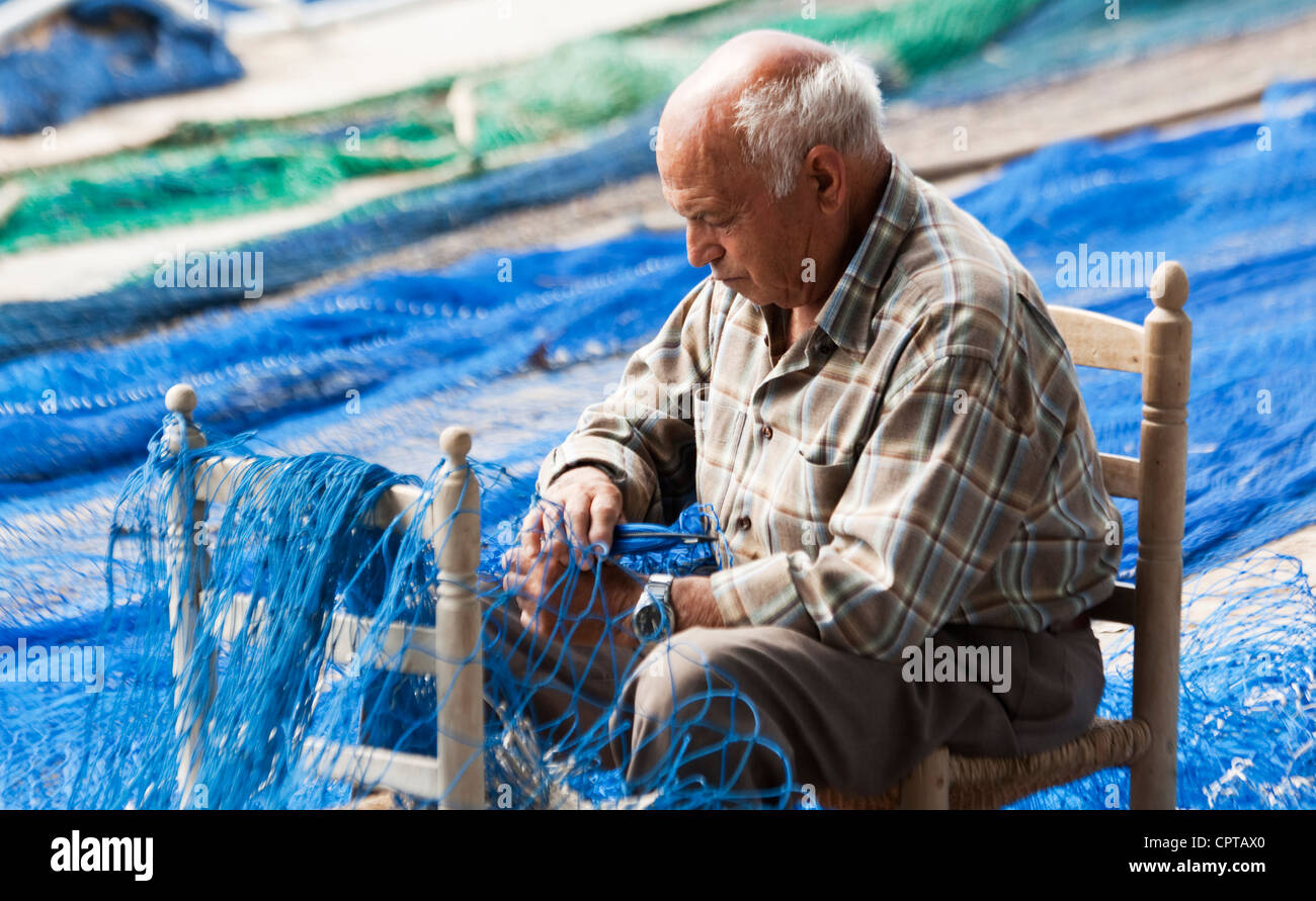 L'homme de réparer les filets de pêche Cambrils Costa Dorada Espagne Banque D'Images