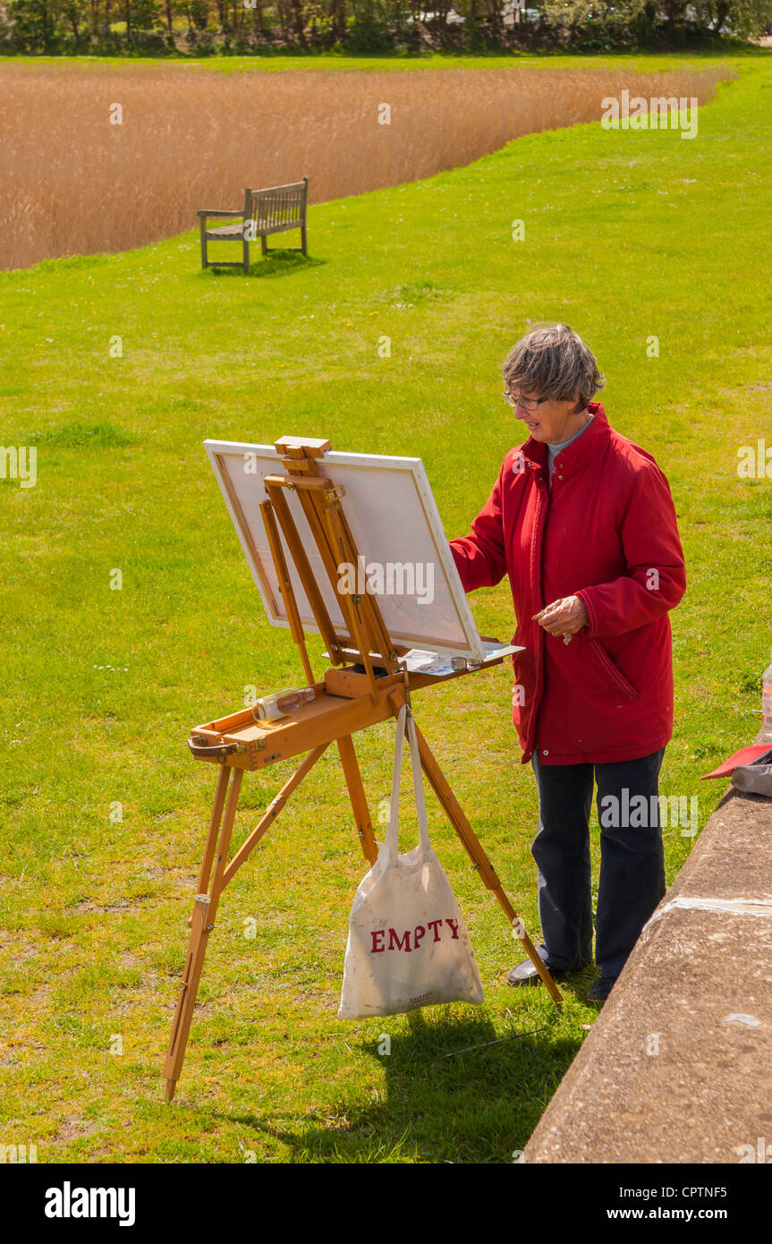Une femme peintre la peinture d'une scène de paysage au Snape Maltings , Suffolk , Angleterre , Angleterre , Royaume-Uni Banque D'Images