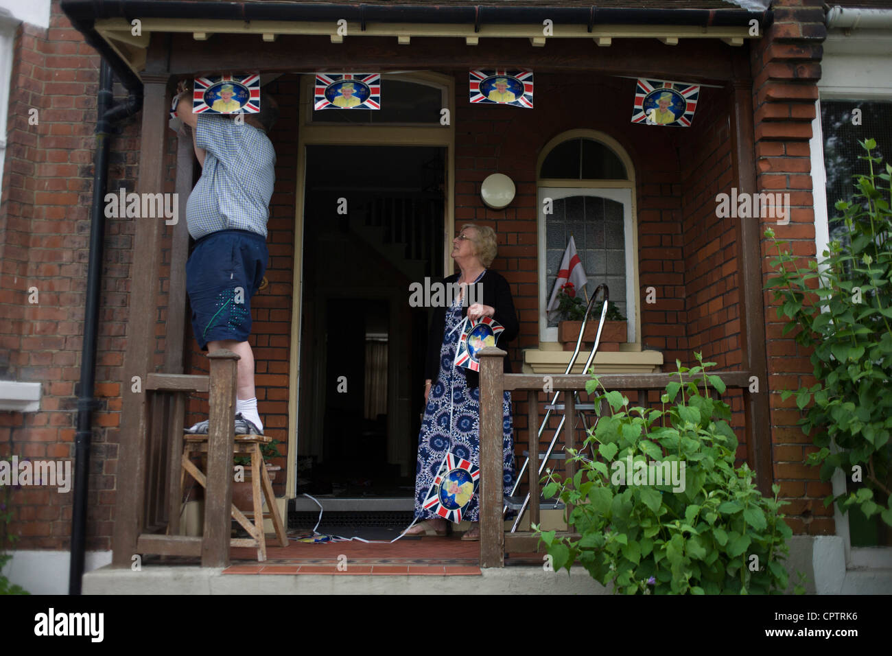 Un couple de Londres royal hang bunting le jour avant le Jubilé de diamant de la reine Elizabeth célébrations dans la véranda de leur maison du sud de Londres avant d'un week-end de célébrations nationales pour le monarque. Banque D'Images