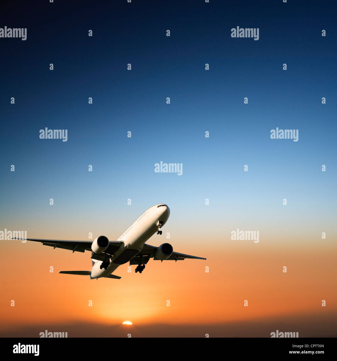 Boeing 777 en venant à la terre au coucher du soleil. Banque D'Images