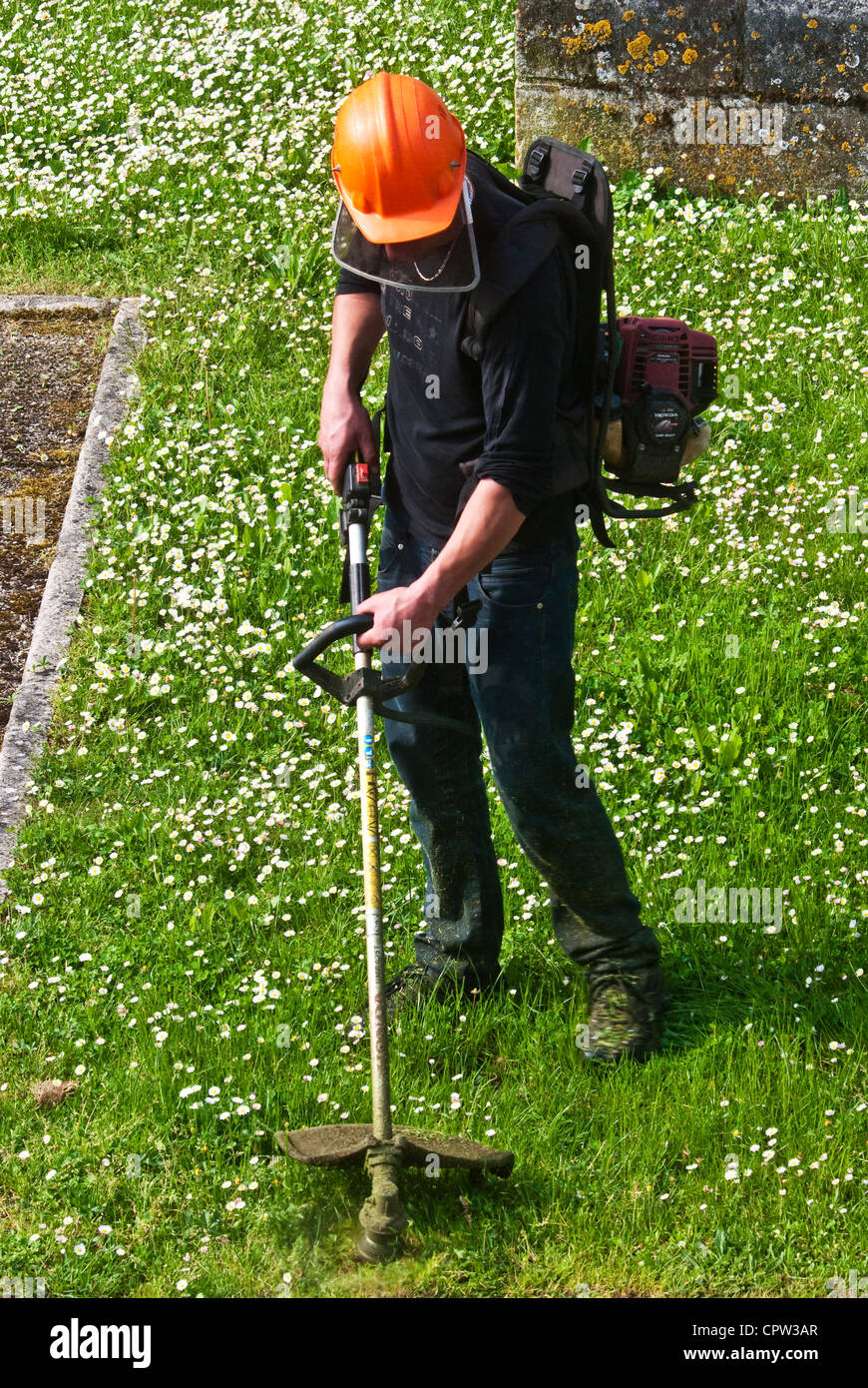 Travailleur du conseil d'herbe strimming frontière - France. Banque D'Images