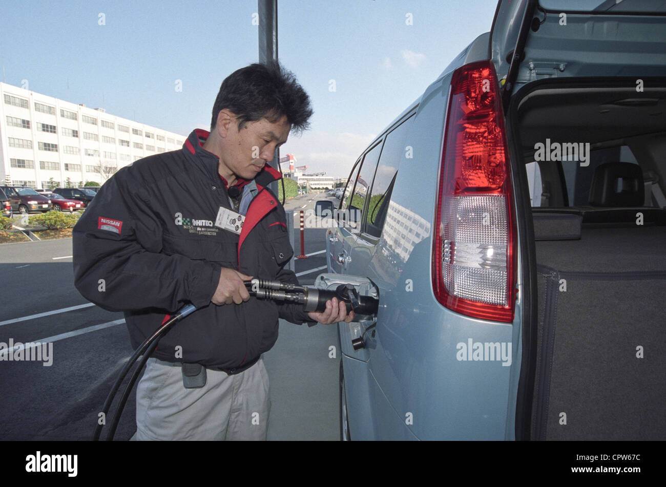 Un ingénieur Nissan remplit le véhicule à pile à combustible avec de l'hydrogène à l'extérieur du centre de recherche Nissan Tokyo, décembre 10, 2002 Banque D'Images