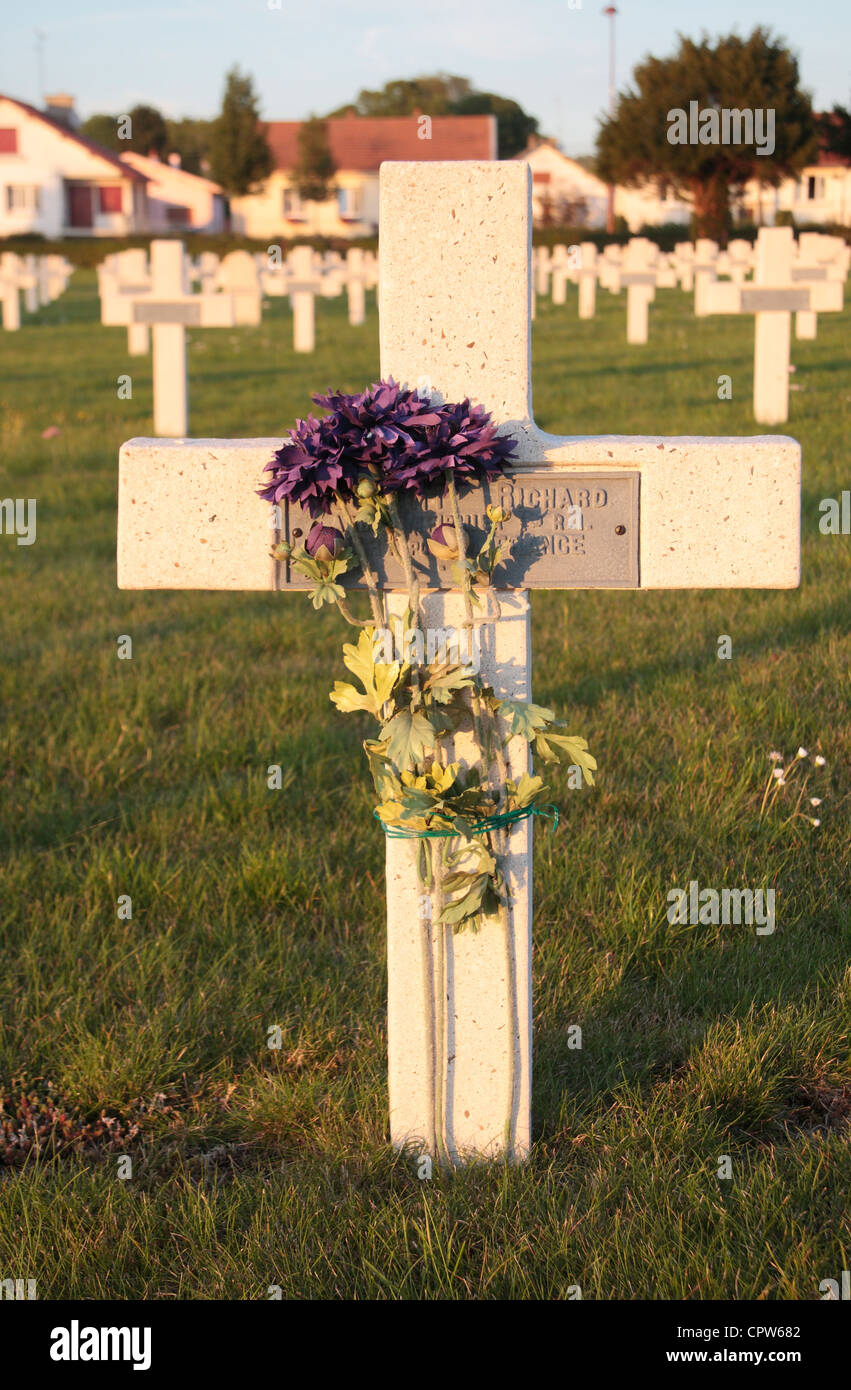 Close up de fleurs sur une pierre tombale croix français dans le Cimetière National Français Bras sur Meuse, Lorraine, France. Banque D'Images