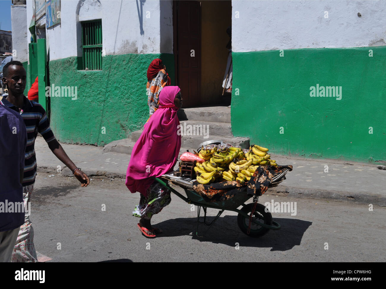 Une femme poussant une brouette pleine de bananes le long d'une rue à l'extérieur de la mosquée Hamoudi dans le centre de la ville de Djibouti, en Afrique de l'est. Banque D'Images