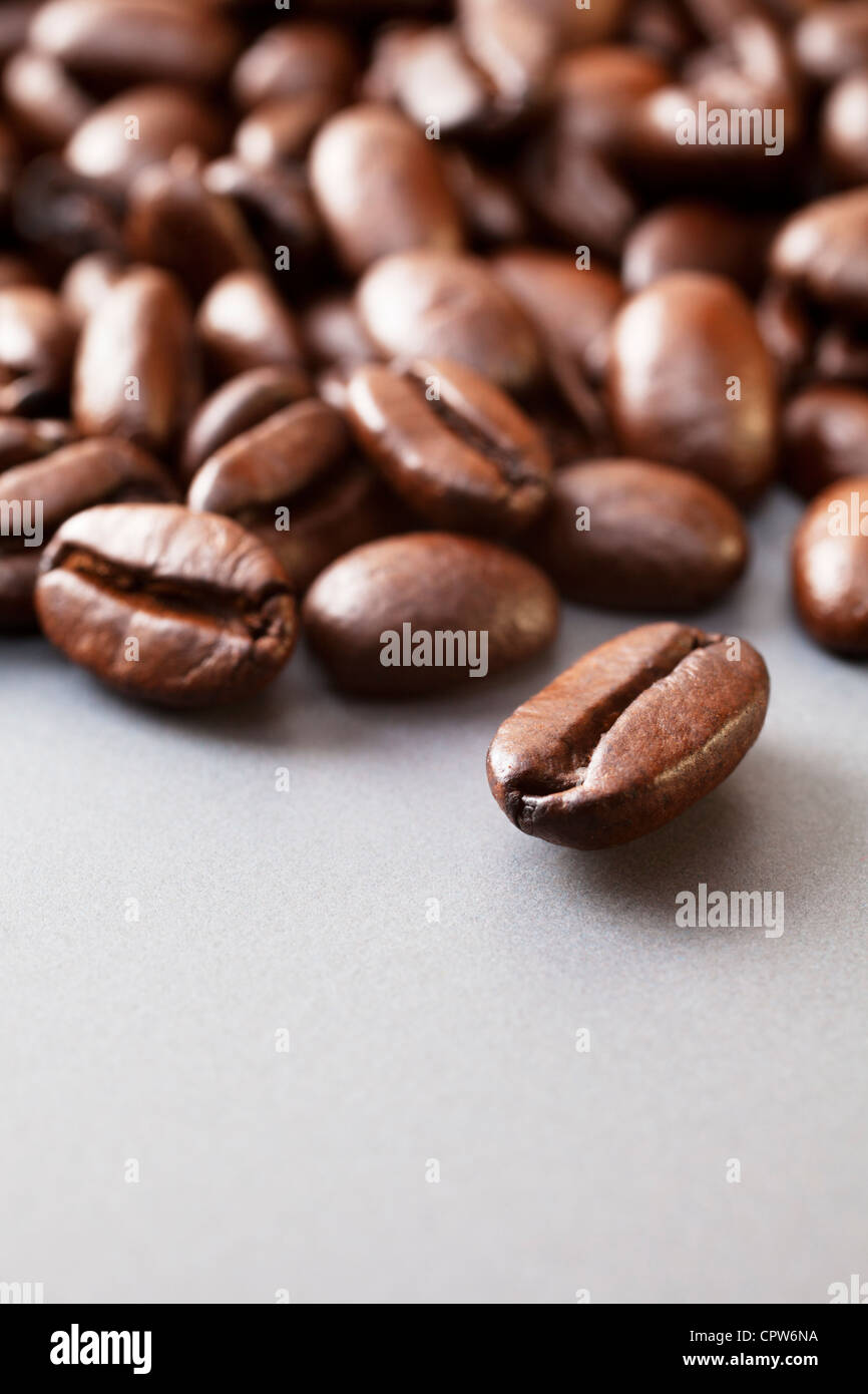 Les grains de café rôti italien frais sur une surface en céramique gris. Banque D'Images