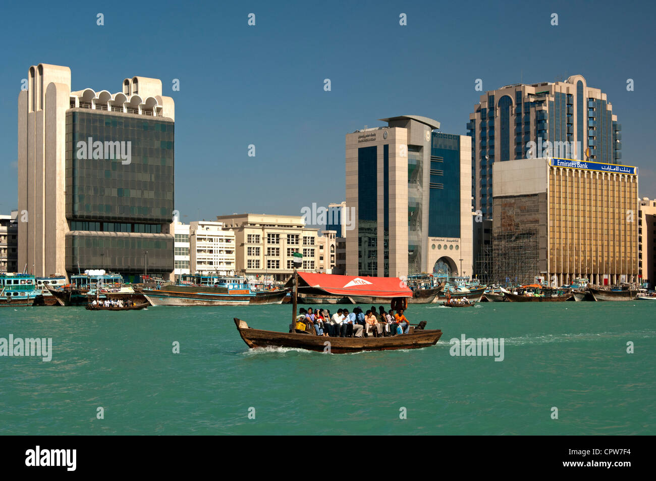 Abra watertaxis sur la Crique de Dubaï en passant par les banques et les bâtiments commerciaux sur la banque de Deira, Dubaï, Émirats Arabes Unis Banque D'Images