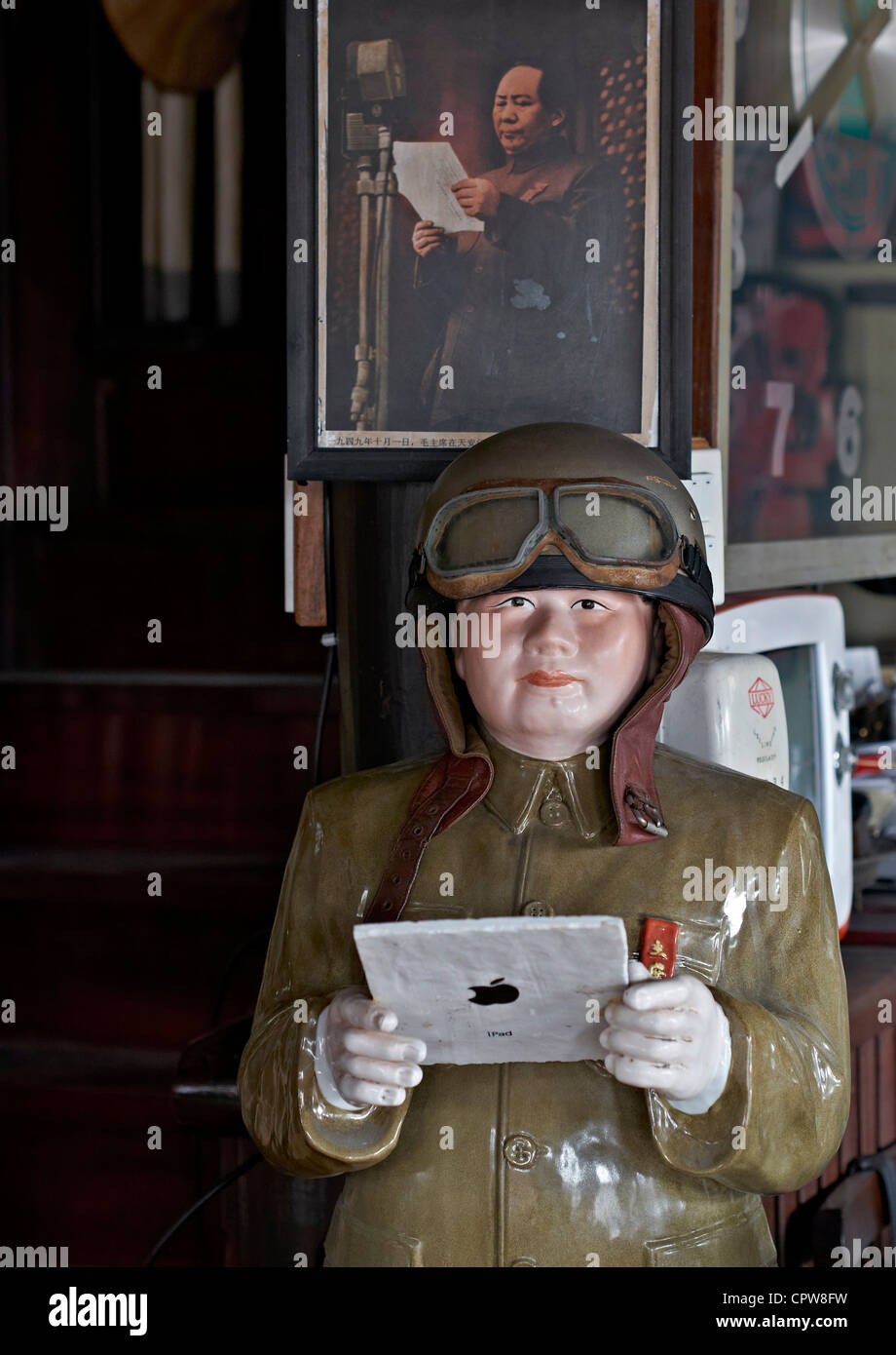 Une statue amusante et une image équivalente appropriée de Mao Tse Tung Zedong se rendant apparemment sur la voie de l'avenir avec une tablette iPad Banque D'Images