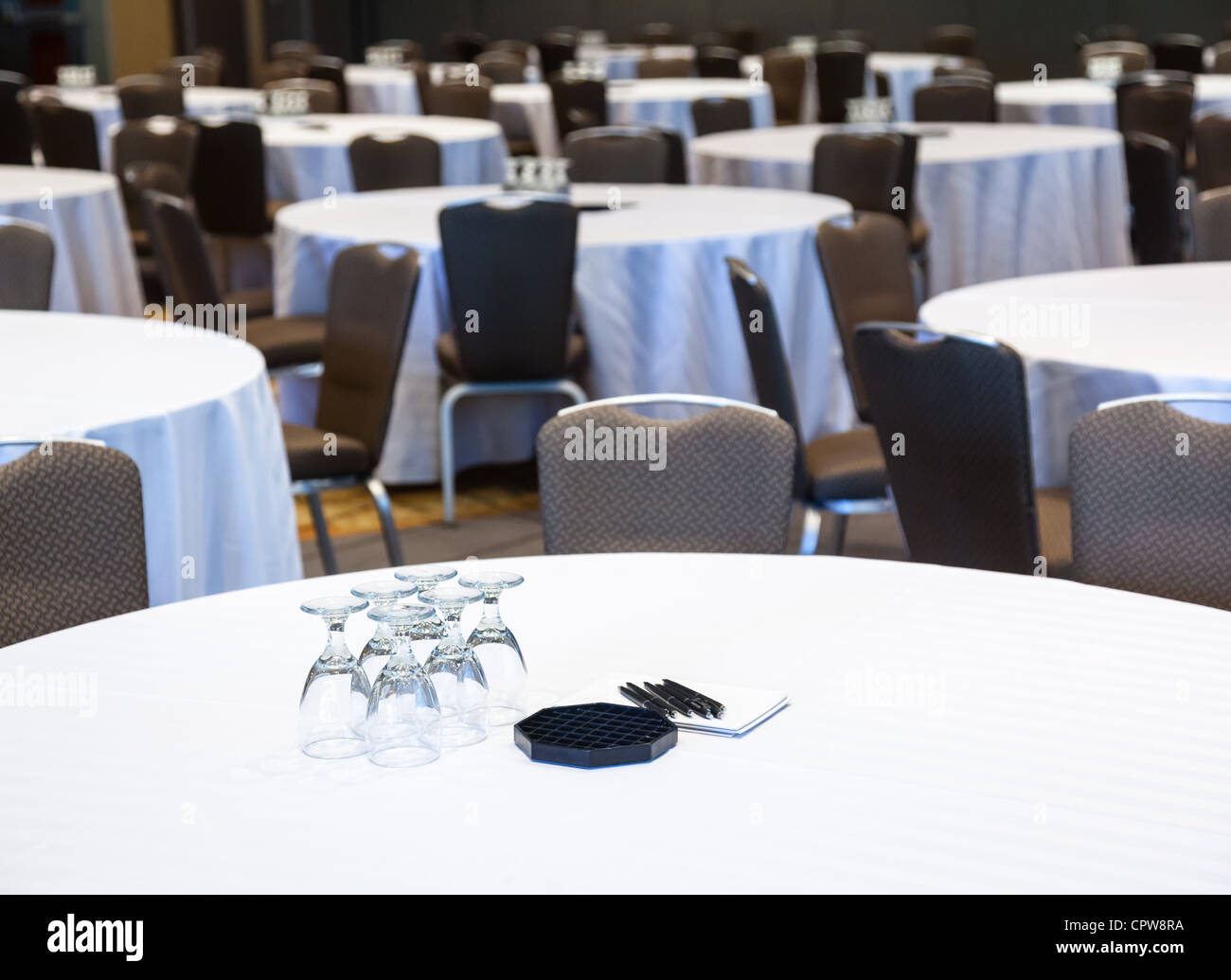 La salle de conférence vide avec de nombreuses tables avec nappes blanches Banque D'Images