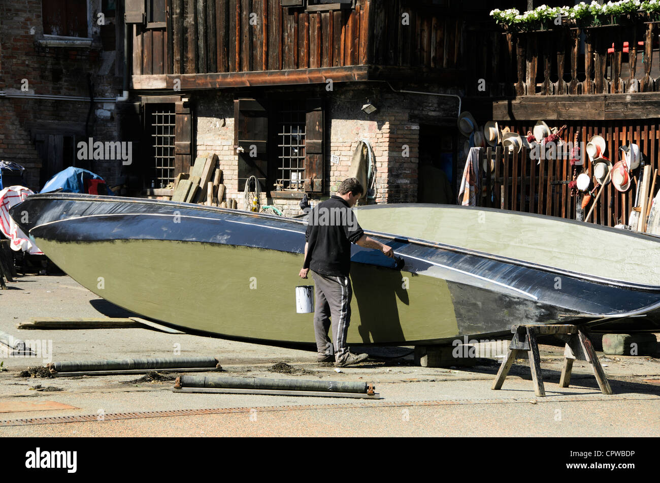 Man painting une gondole - 'Squero di San Trovaso' atelier gondole - sestiere Dorsoduro, Venise - Italie Banque D'Images