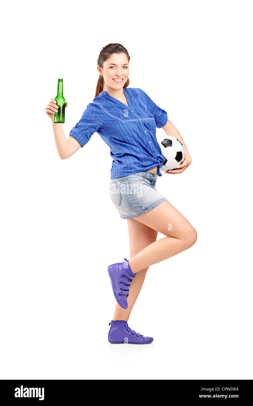 Full Length portrait of a young woman holding a football du ventilateur et bouteille de bière isolé sur fond blanc Banque D'Images