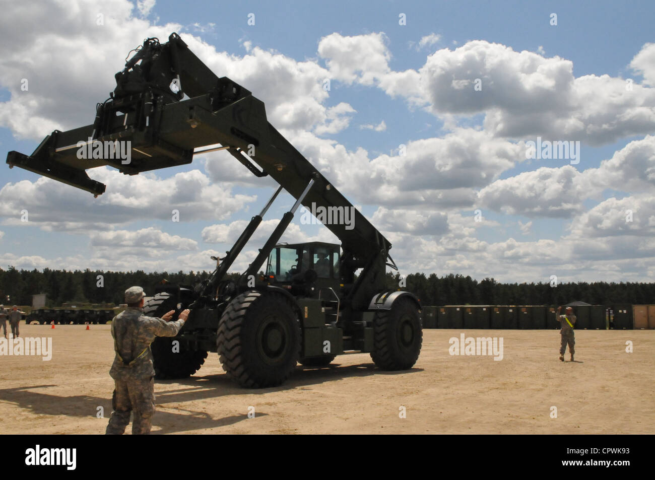 Le sgt. oscar anderson, 453e compagnie de transport de fret à l'intérieur des terres, Corpus Christi, Texas, fournit la masse des signaux de guidage pour l'opérateur du terrain accidenté-container, RT240, au cours de l'exercice Red dragon 2012 à fort mccoy, wis. Banque D'Images