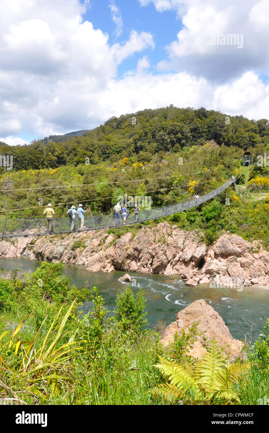 Nouvelle Zélande, île du Sud, parc national Abel Tasman. Les gens randonner pont suspendu. Banque D'Images