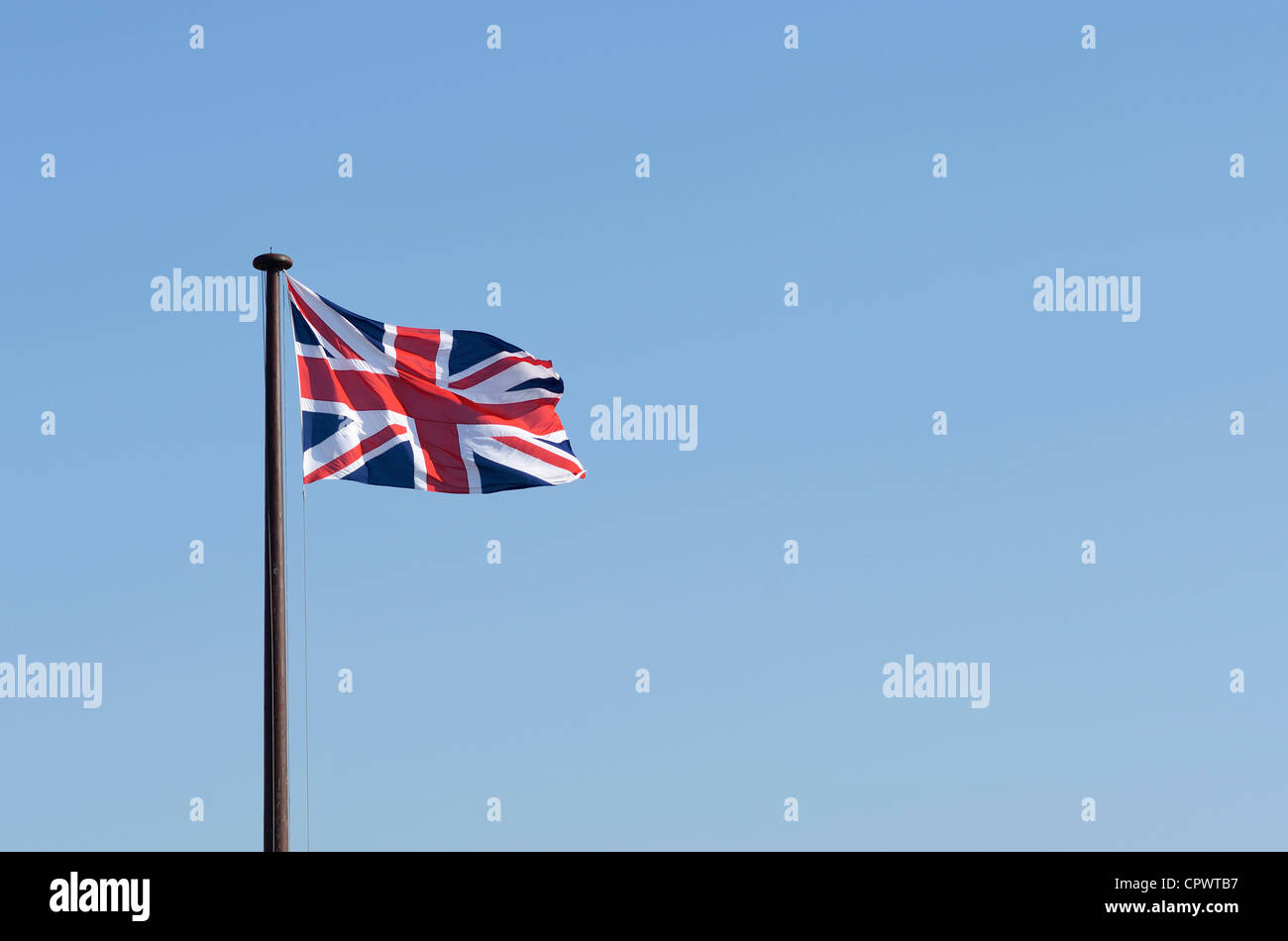 Union Jack flag flying against a blue sky Banque D'Images