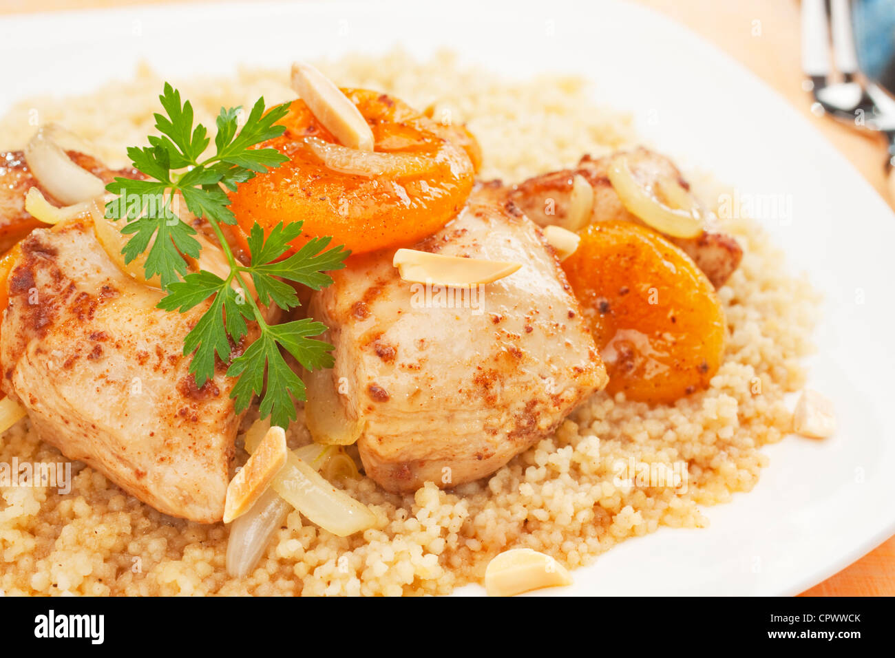 Un plat marocain, tajine de poulet aux abricots et a servi plus de couscous. Le tagine est parfumée avec le gingembre, la cannelle, le piment et le miel. Banque D'Images
