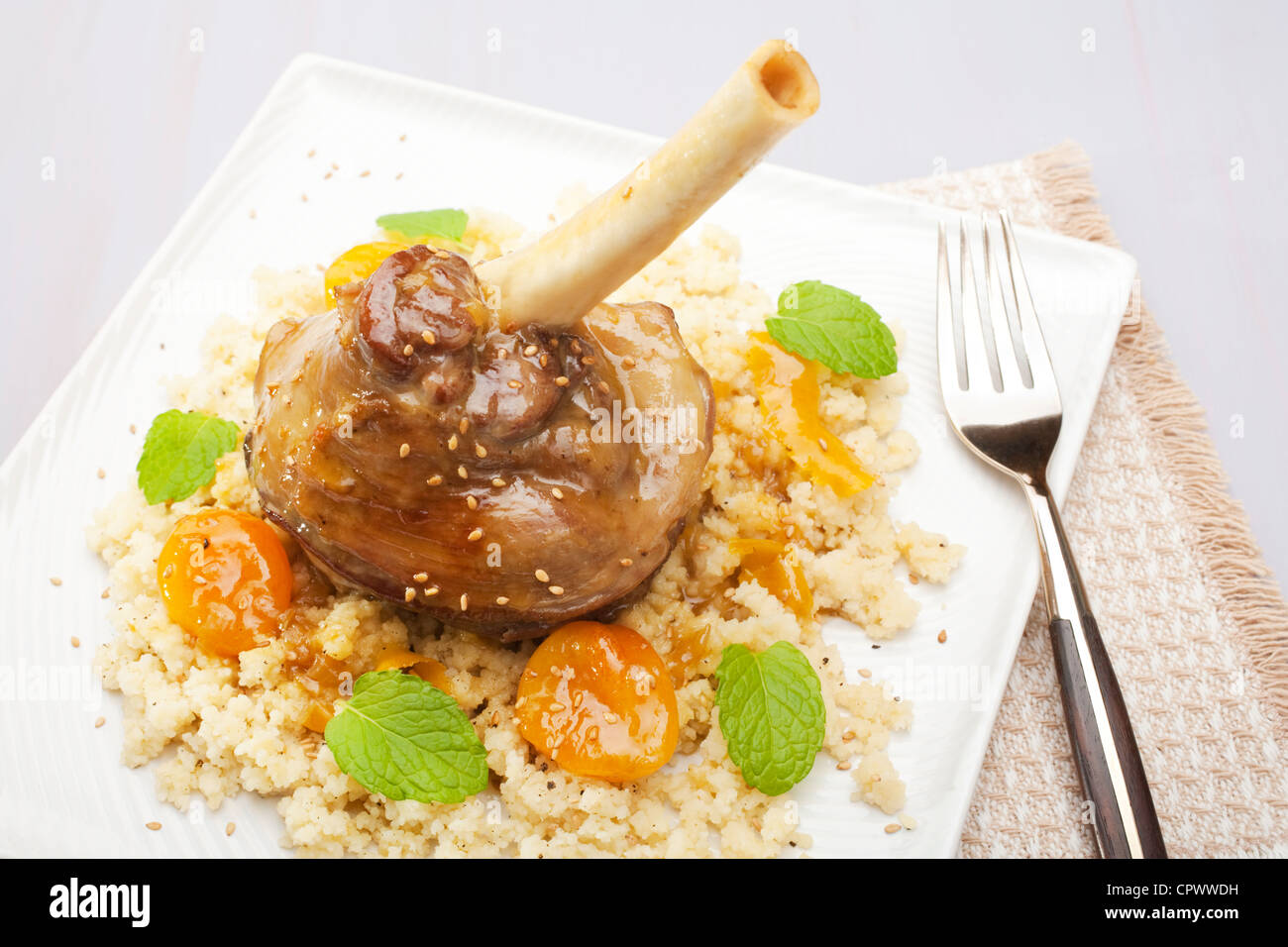 Tajine marocain d'agneau, cuit avec le gingembre, la cannelle, le miel et les abricots, a servi plus de couscous. Banque D'Images