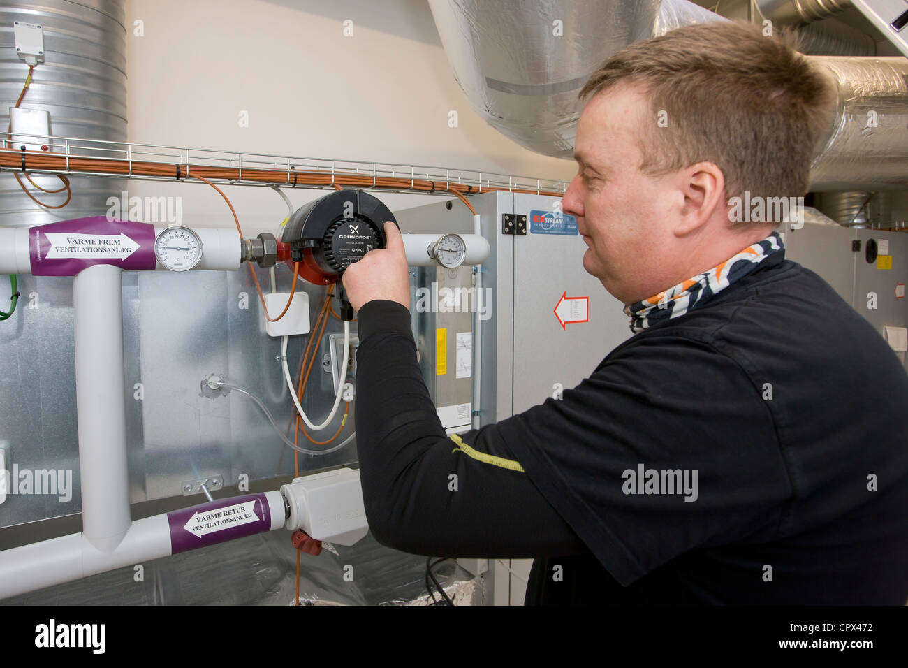 Technicien en chauffage et sanitaire régler une pompe de circulation Banque D'Images