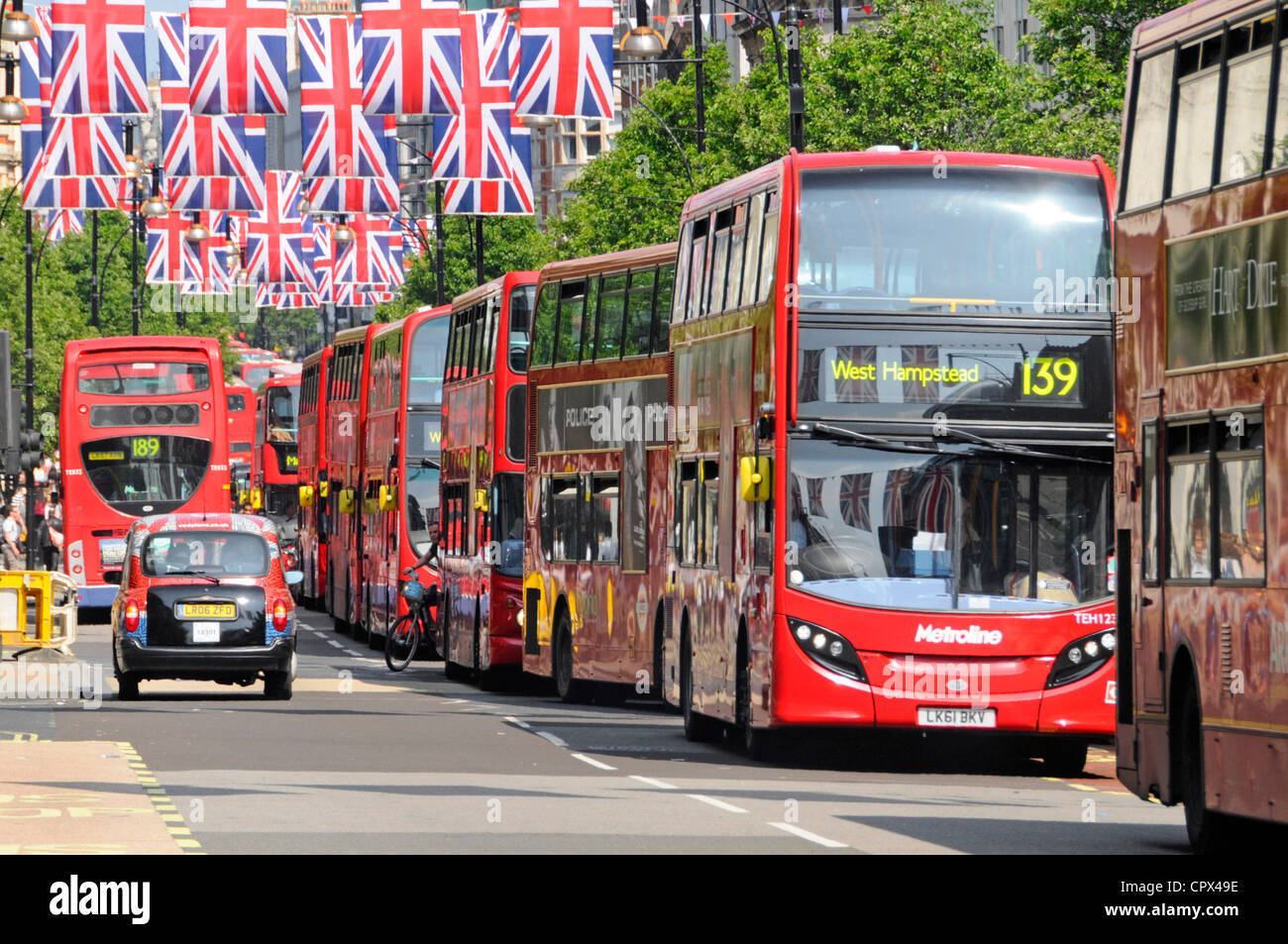 Scène de rue à Londres Oxford Street Union Jack Flags Queens Jubilee & célébrations des Jeux Olympiques de 2012 d'attente d'autobus de la ville de contribuer à la pollution de l'UK flag Banque D'Images