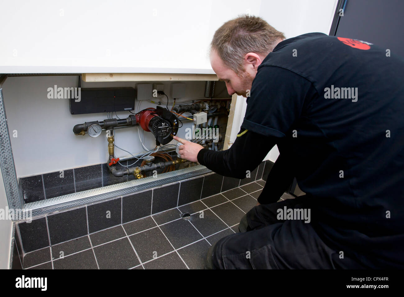 Technicien en chauffage et sanitaire régler une pompe de circulation Banque D'Images
