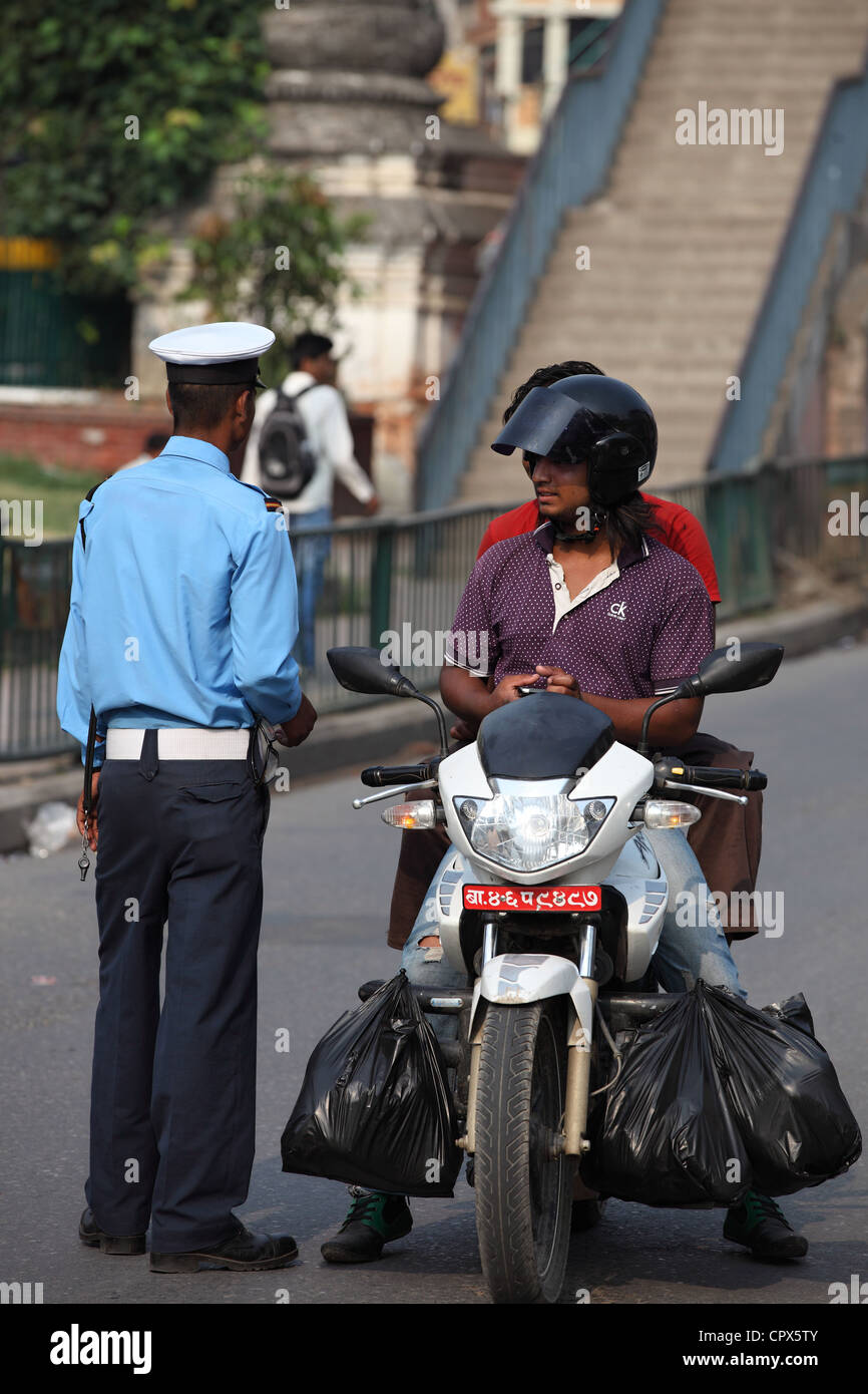 Agent de police contrôlant une moto au Népal Banque D'Images