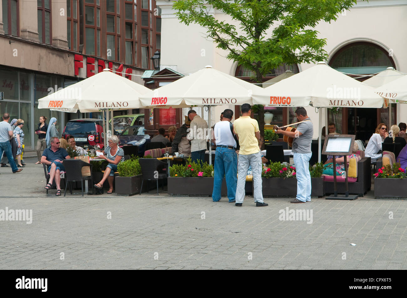 Buskers tzigane jouant à l'avant du café à la place du marché principale, Cracovie, Pologne. Banque D'Images