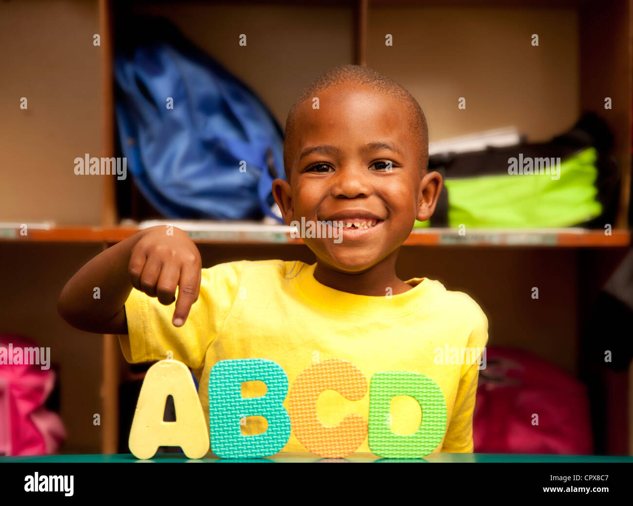 Enfant souriant de jouer le jeu de lettres de l'alphabet Banque D'Images