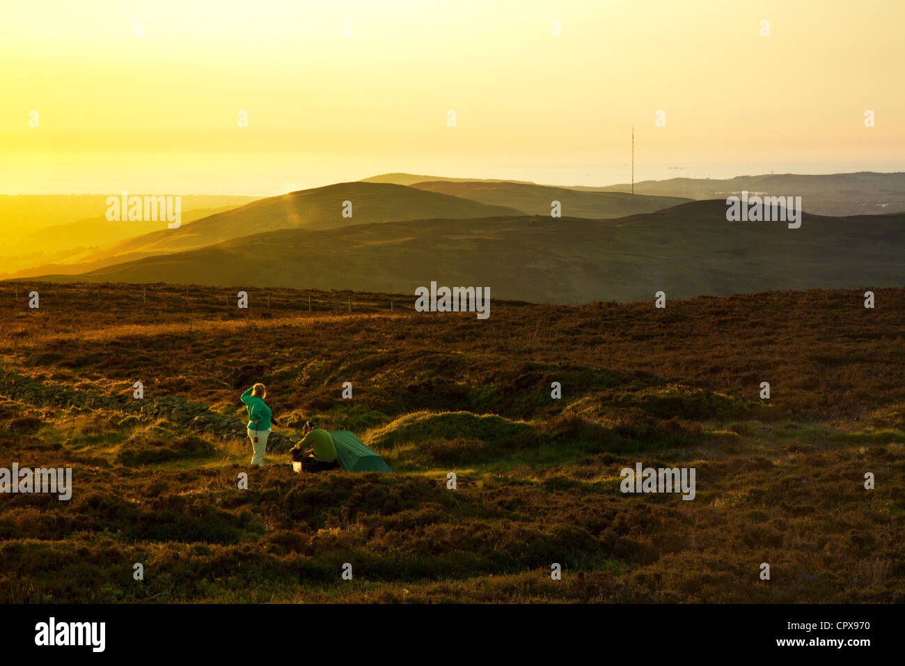 Un couple de camping sauvage sur le Moel Famau haut de gamme avec vue sur la Clwydian vers Pennycloddiau et Moel y Parc Banque D'Images