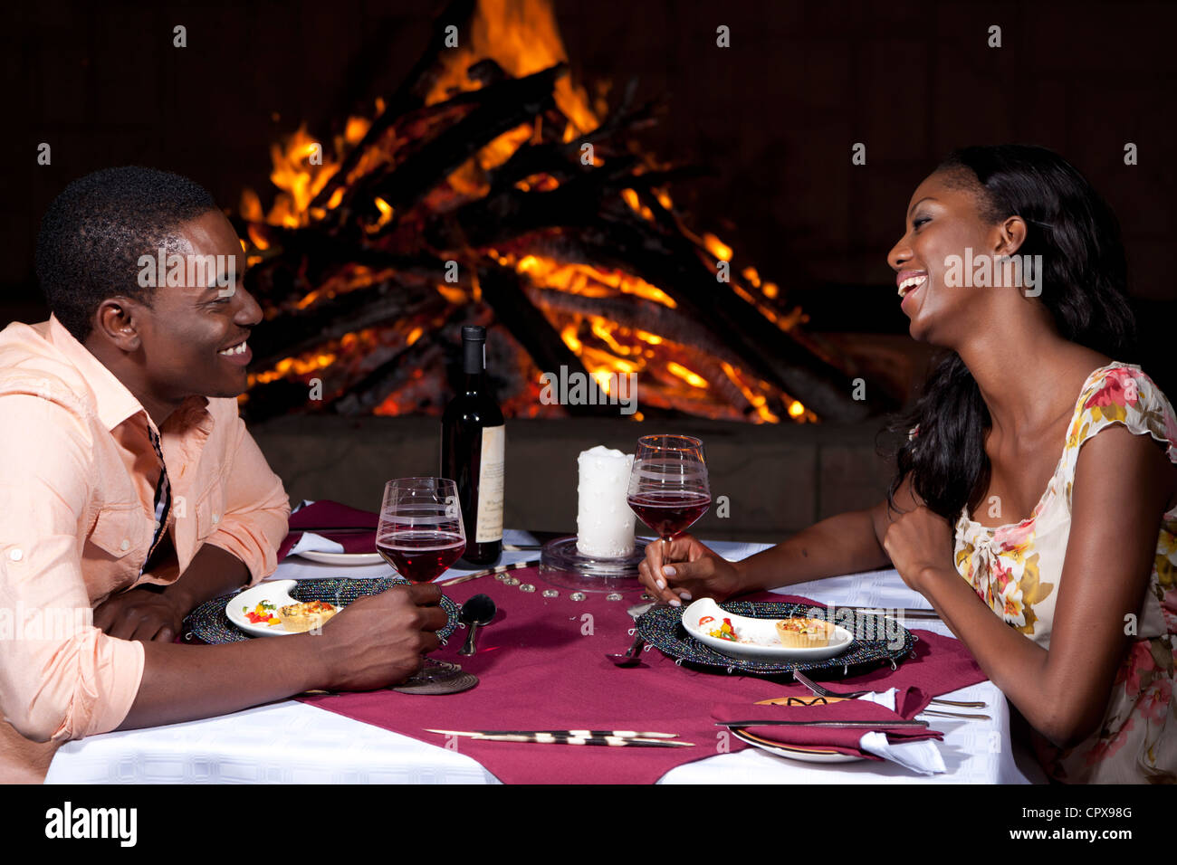 Un couple en train de dîner en plein air à côté d'un incendie Banque D'Images