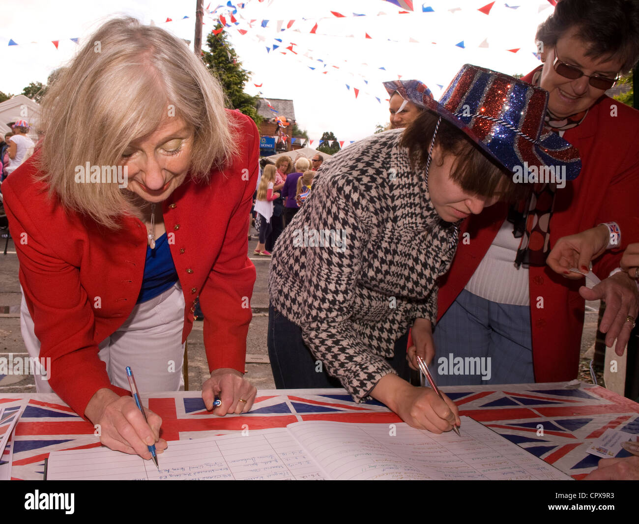 Les gens de signer le livre d'or sur les célébrations du Jubilé de diamant de la Reine, Rowledge Village, Surrey/Hampshire border Banque D'Images