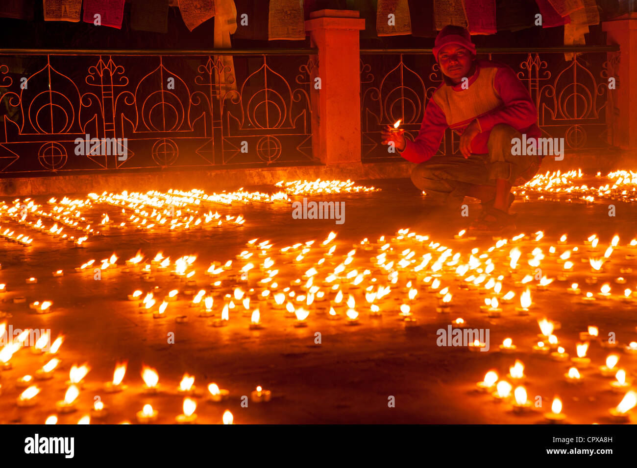 L'offre de l'homme tenir la lumière de bougie dans le Temple de la Mahabodhi, Bodh Gaya, Bihar, Inde Banque D'Images