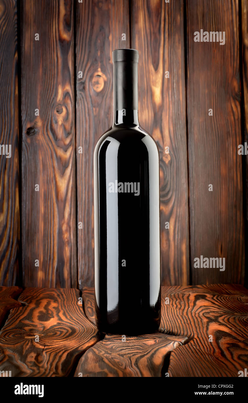Bouteille de vin rouge sur un fond de bois Banque D'Images
