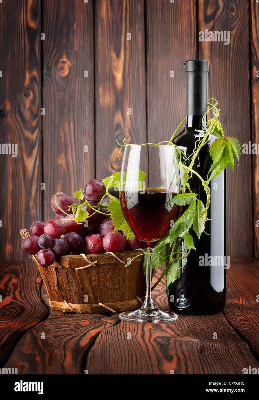 Vin rouge avec un verre de vin sur fond de bois Banque D'Images
