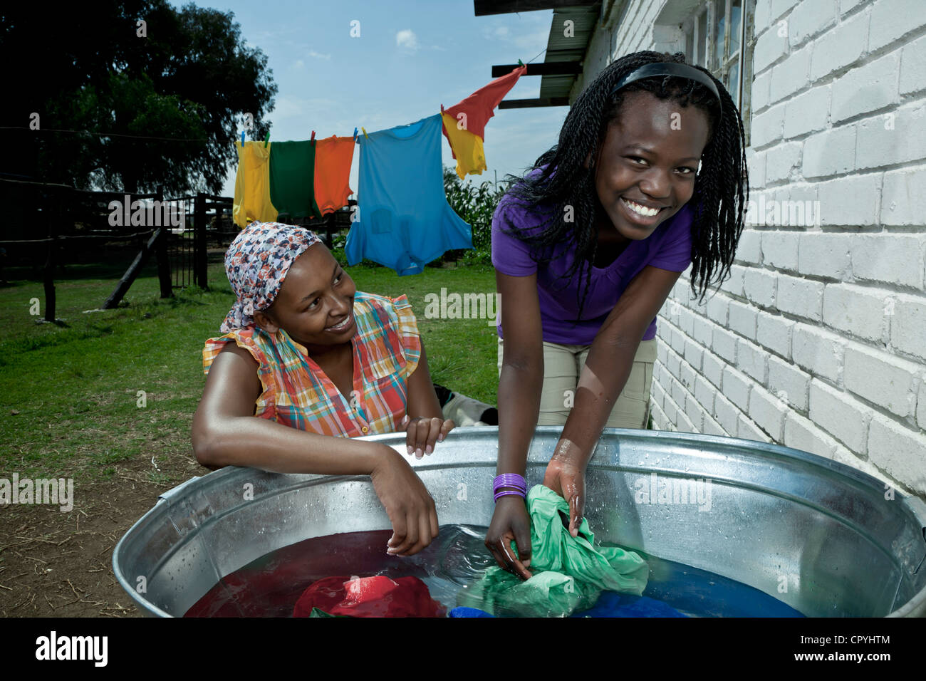 Main de femme noire se lave à l'extérieur de son foyer rural de vêtements  avec sa fille Photo Stock - Alamy