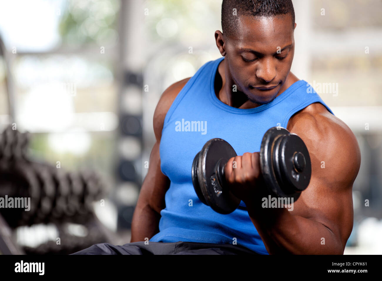 Jeune homme noir musclé soulever des poids dans une salle de sport Photo  Stock - Alamy