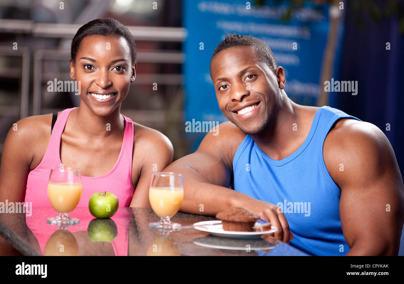 Deux jeunes amis noirs de manger dans une salle de sport, smiling Banque D'Images
