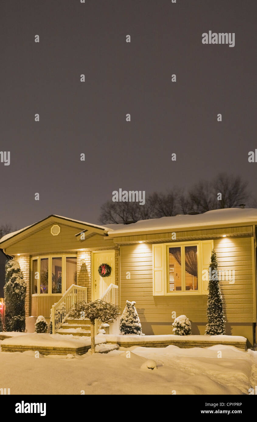 Maison de style bungalow allumé en hiver au crépuscule avec des décorations de Noël, Québec, Canada Banque D'Images
