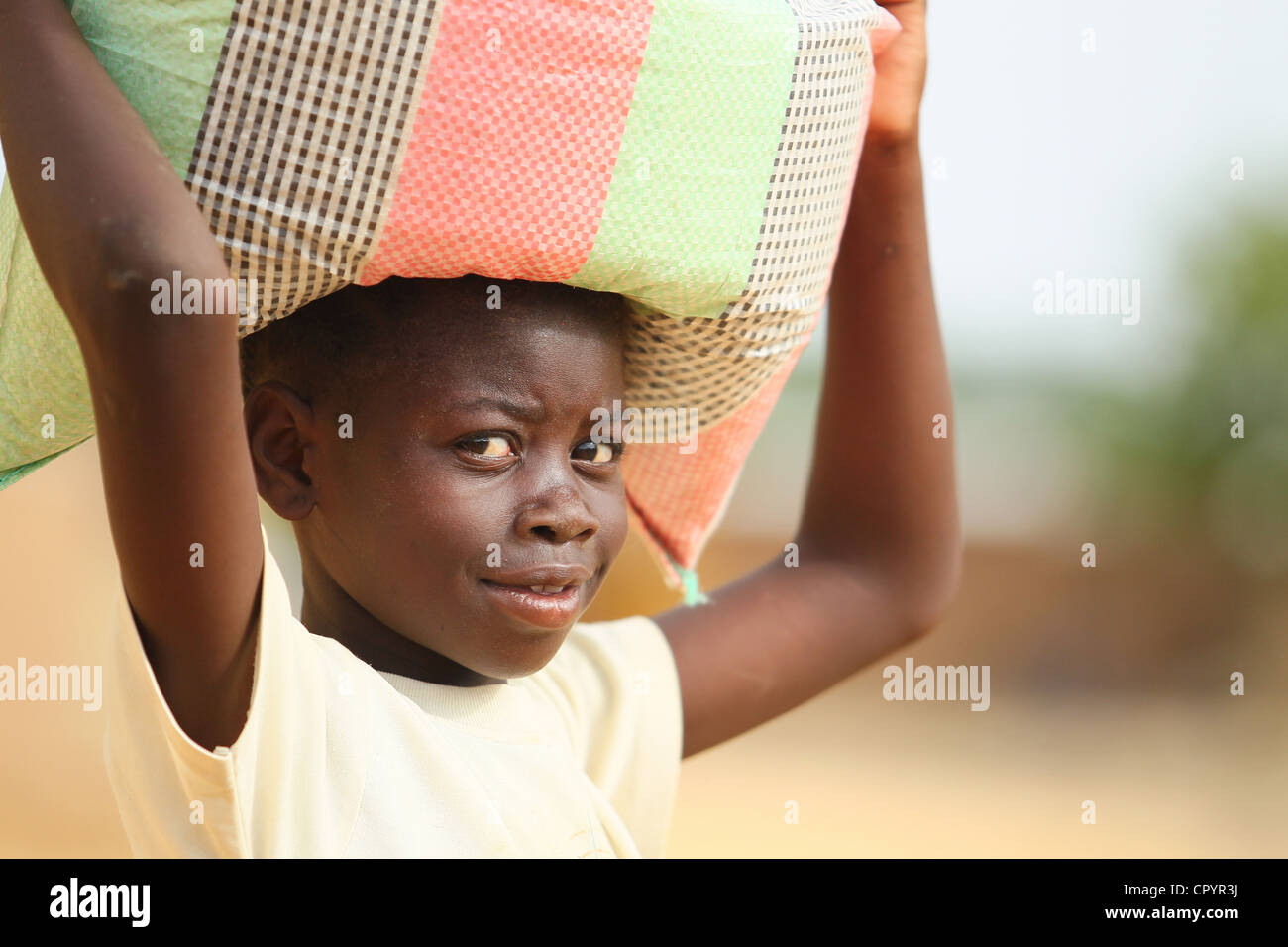 Une fille porte une charge sur le dessus de sa tête à N'Djamena, Tchad le jeudi 10 juin 2010. Banque D'Images