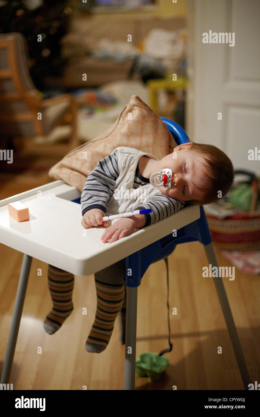 Bebe 8 Mois Dormir Avec Sucette Dans La Bouche Et Une Plume A La Main Dans Un Siege Pour Enfant Photo Stock Alamy