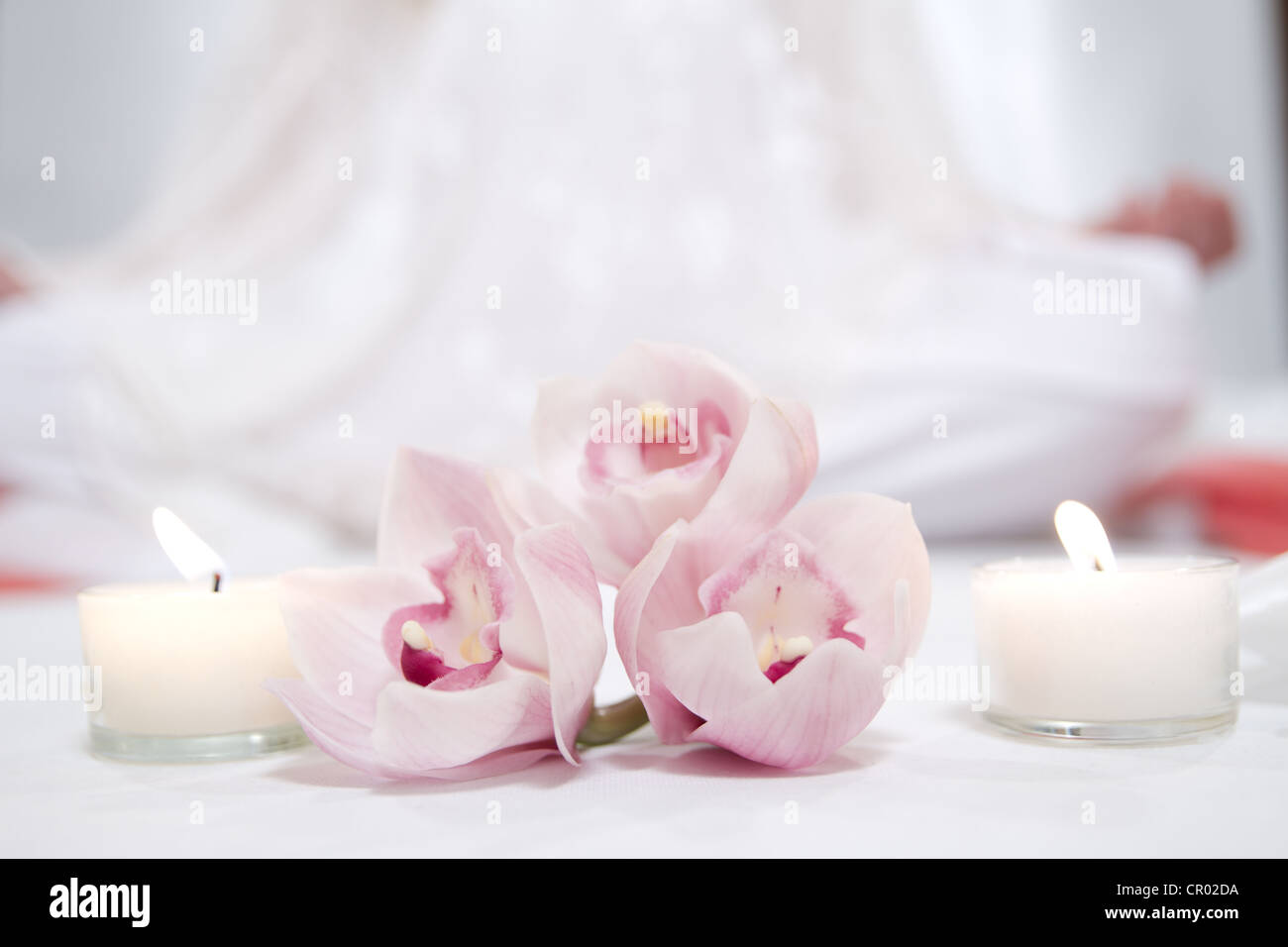 Orchidées rose isolé avec deux bougies et méditant figure sur le contexte Banque D'Images