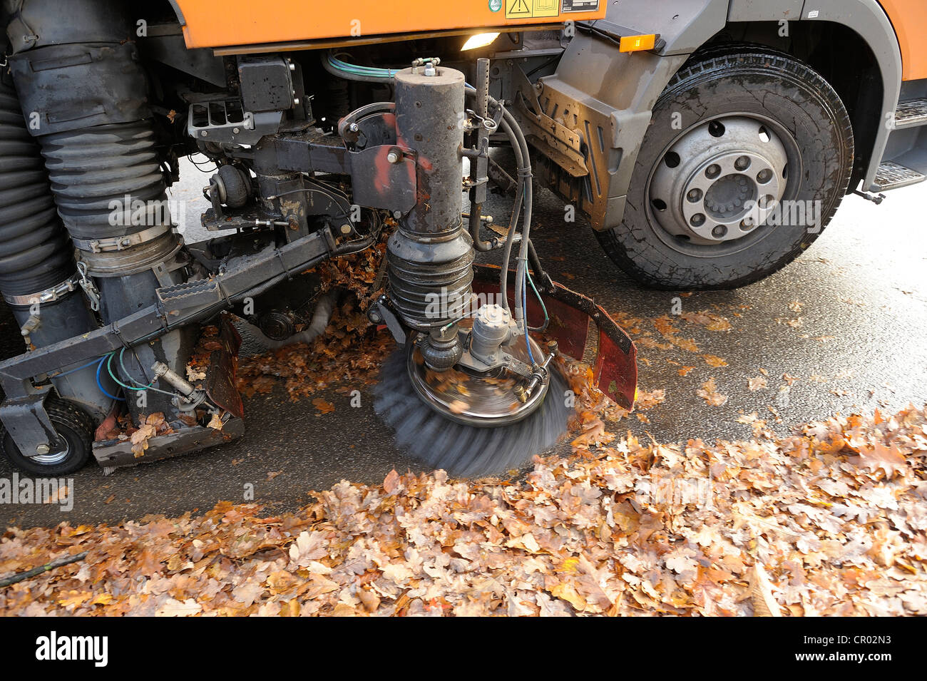 Street Sweeper l'enlèvement des feuilles dans une ville Banque D'Images