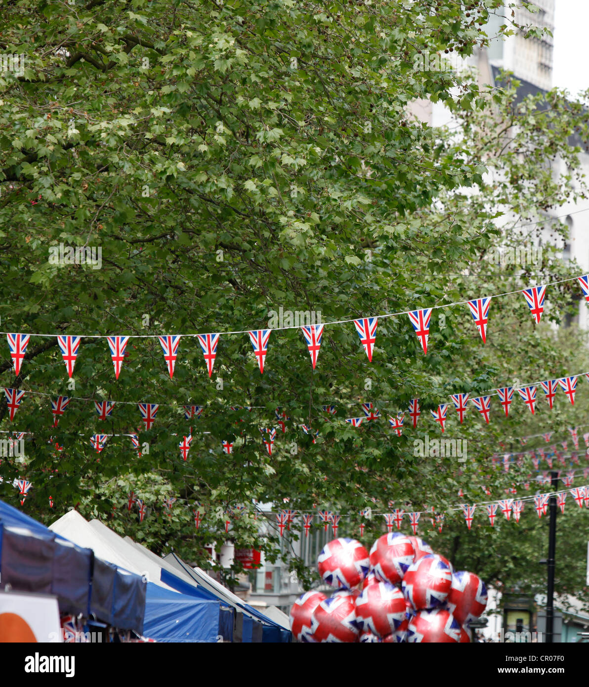 Union Jack bunting ou fanions suspendus partout Street à Birmingham. Un vendeur de ballons ballons patriotique avec. Banque D'Images