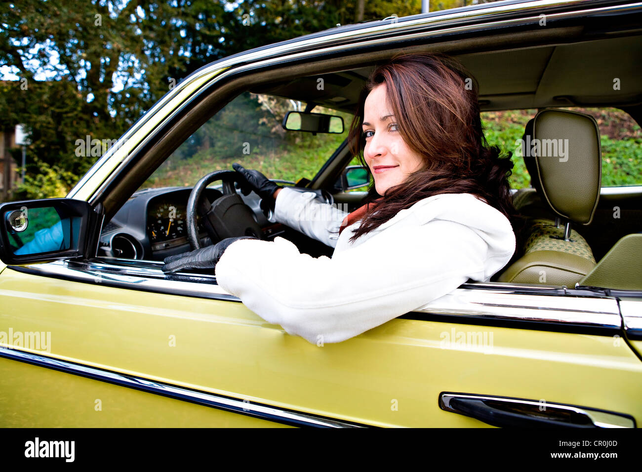Jeune femme dans une voiture classique de l'après-guerre Banque D'Images