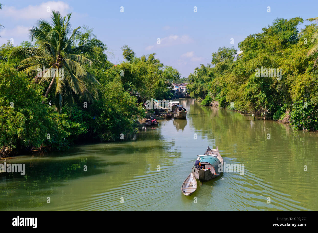 Petit bateau à moteur en passant par un canal d'eau entourée de végétation tropicale, Hue, Vietnam, Asie Banque D'Images