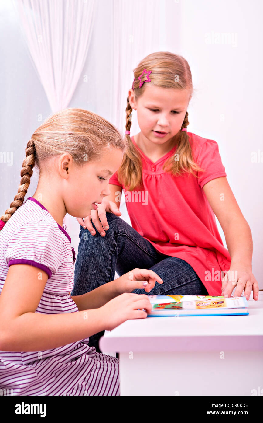 Deux jeunes écolières assis au bureau, faire leurs devoirs Banque D'Images