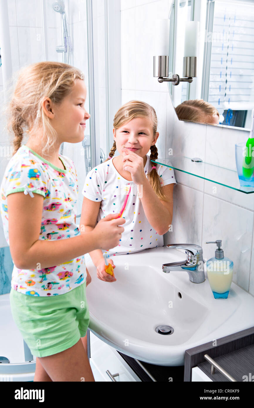 Les soeurs se brosser les dents dans la salle de bains Banque D'Images