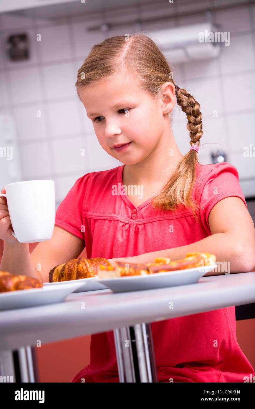 Jeune fille ayant le petit déjeuner dans la cuisine Banque D'Images