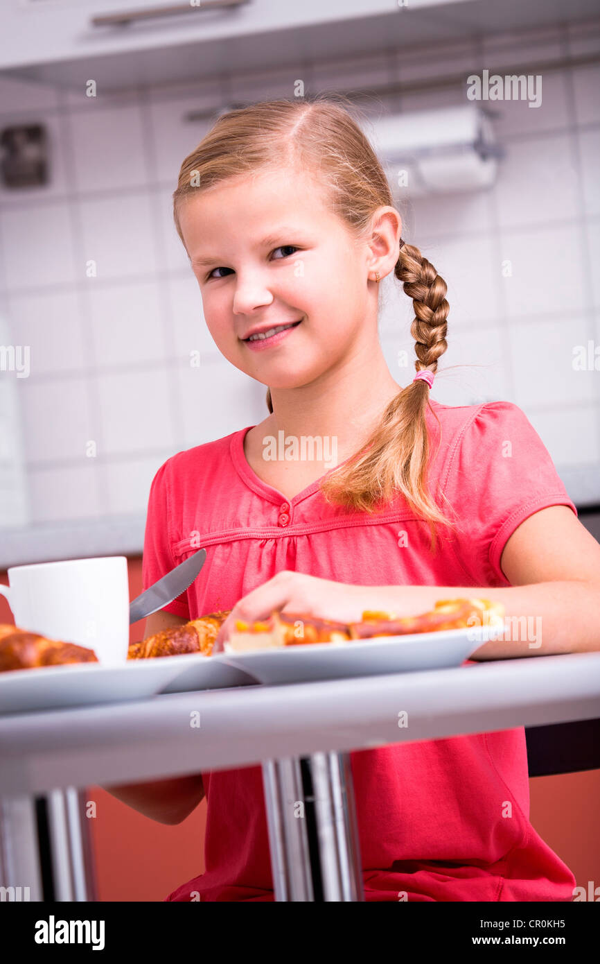 Jeune fille ayant le petit déjeuner dans la cuisine Banque D'Images