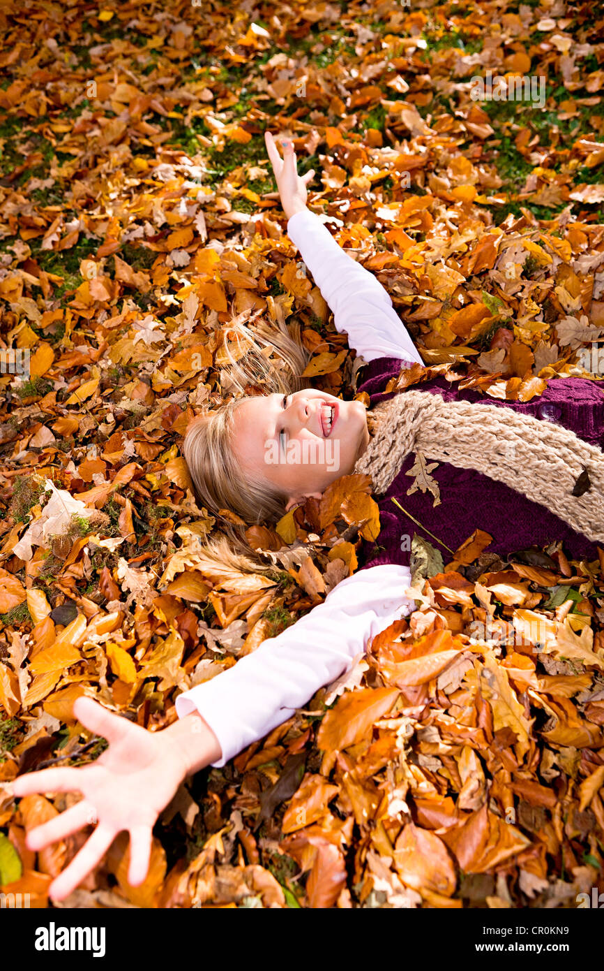 Entouré de fille les feuilles d'automne Banque D'Images