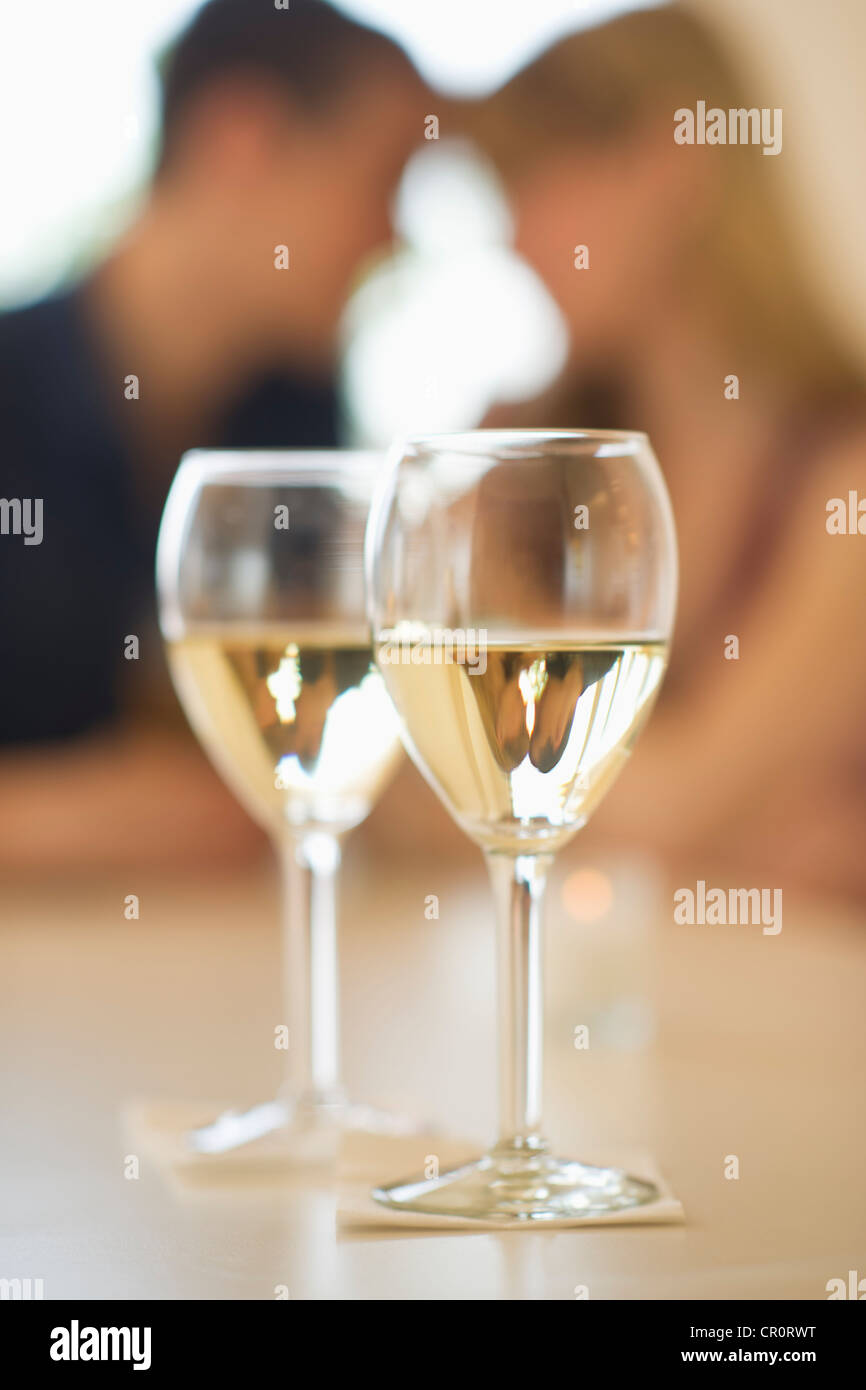 USA, New Jersey, Jersey City, Close up de verres à vin avec couple en arrière-plan Banque D'Images