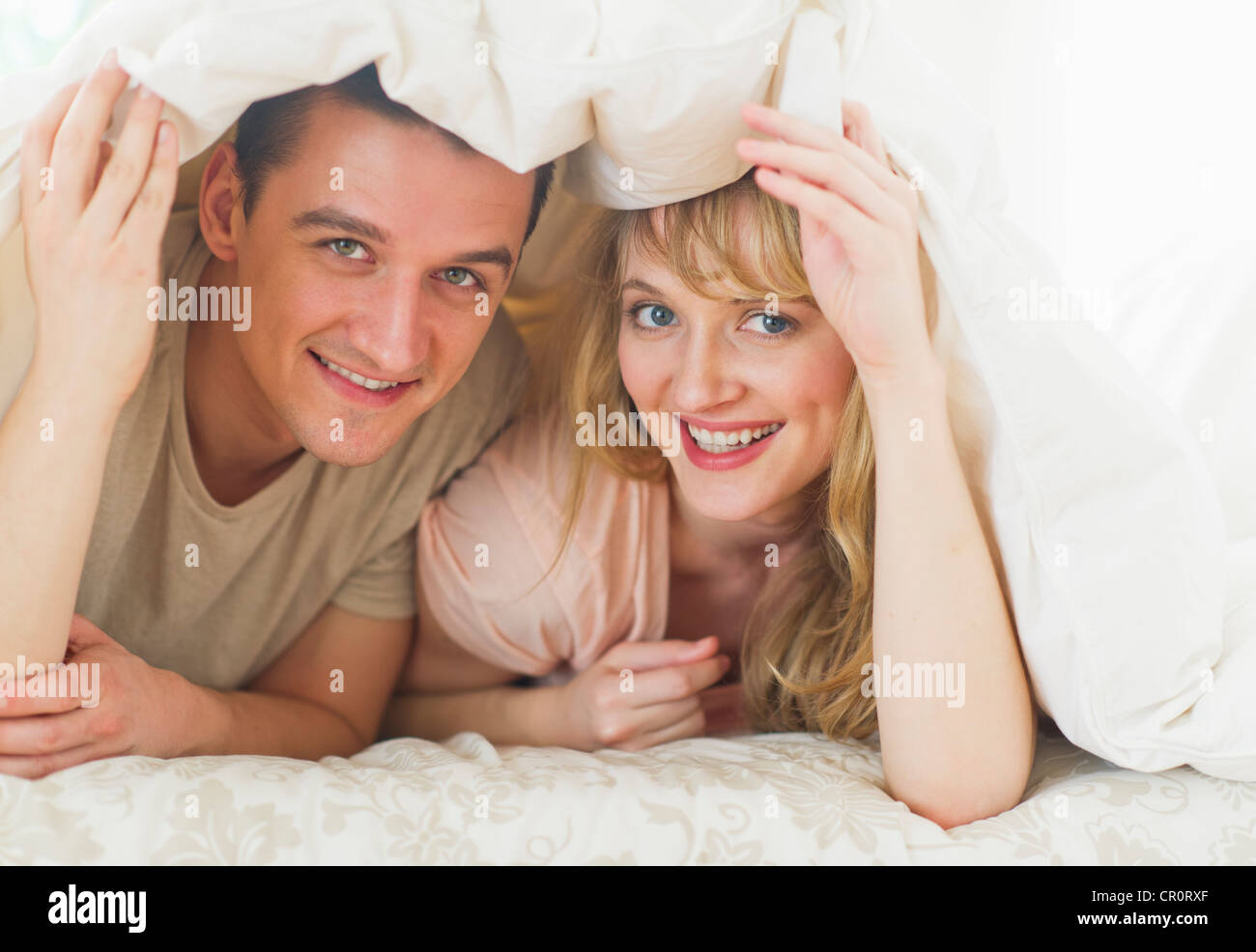 USA, New Jersey, Jersey City, Couple lying on bed sous couette Banque D'Images