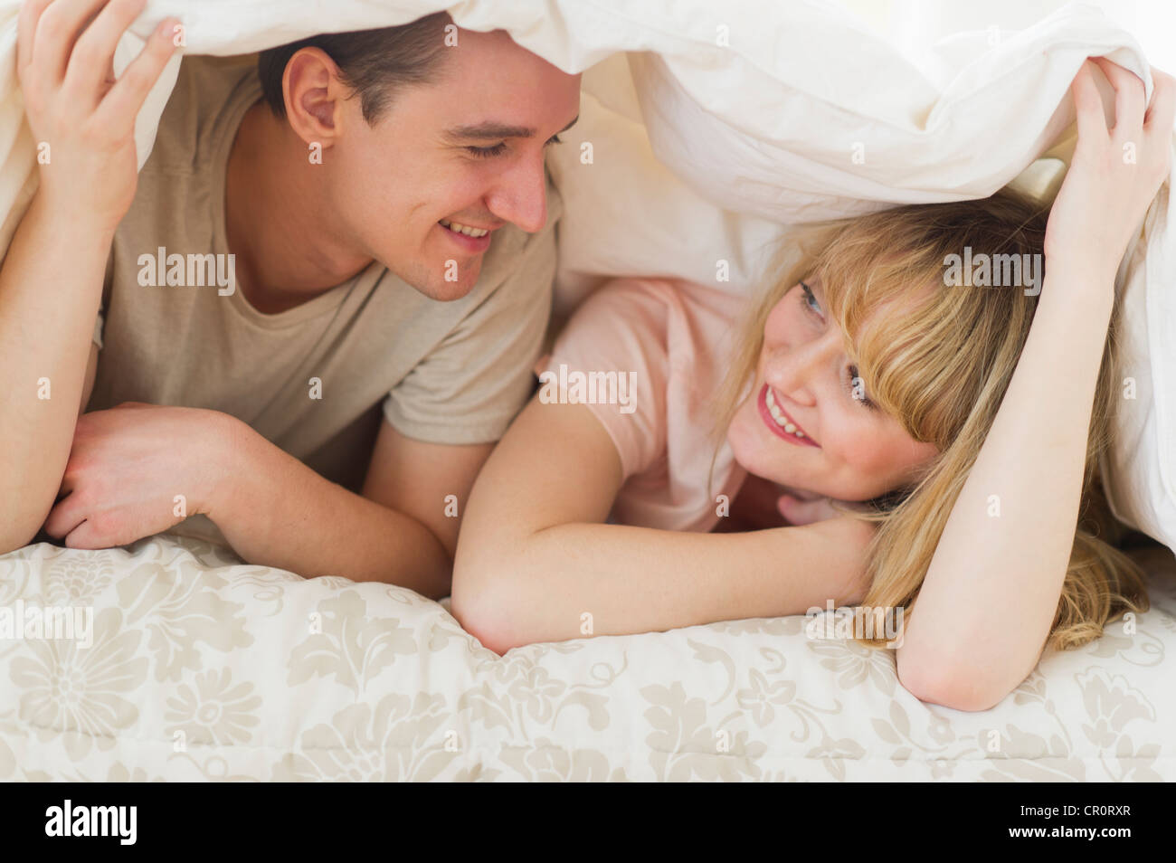 USA, New Jersey, Jersey City, Couple lying on bed sous couette Banque D'Images